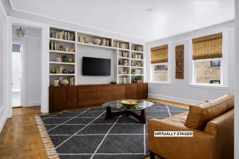 a living room with furniture a flat screen tv and windows