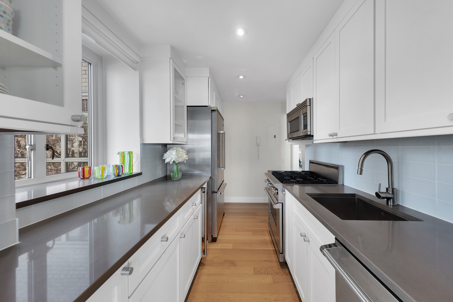 200 East 66th Street, Unit A407 Manhattan, NY 10065 - Photo 5 of 24 a kitchen with stainless steel appliances granite countertop a sink and cabinets
