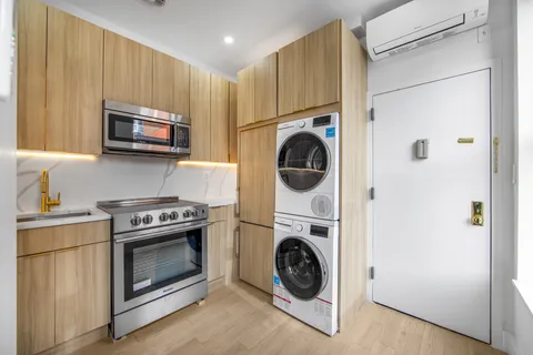 a kitchen with a stove top oven a refrigerator and washer