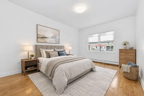 a bedroom with a bed and wooden floor