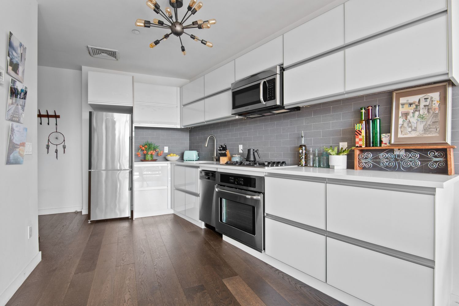 179 Woodpoint Road, Unit 4A Brooklyn, NY 11211 - Photo 3 of 16 a kitchen with stainless steel appliances granite countertop a refrigerator a stove top oven a sink and dishwasher with wooden floor