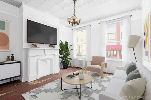 a living room with furniture a flat screen tv and a chandelier