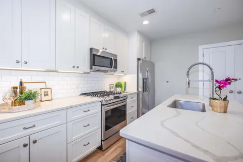 a kitchen with white cabinets and stainless steel appliances