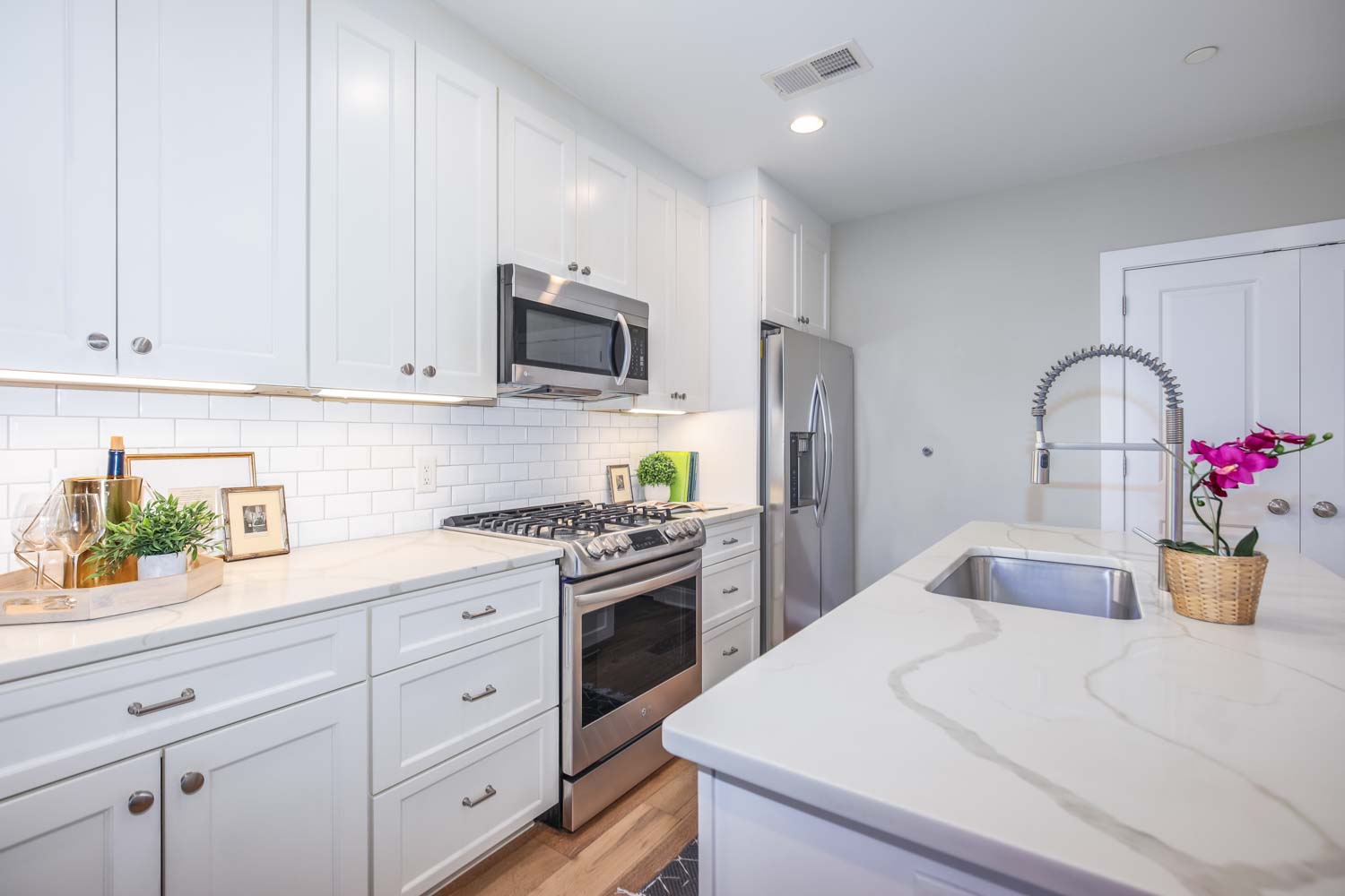 3123 Warder Street Northwest, Unit 1 Washington, DC 20010 - Photo 9 of 24 a kitchen with white cabinets and stainless steel appliances