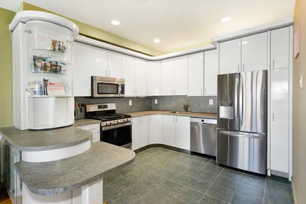 a kitchen with granite countertop stainless steel appliances and refrigerator