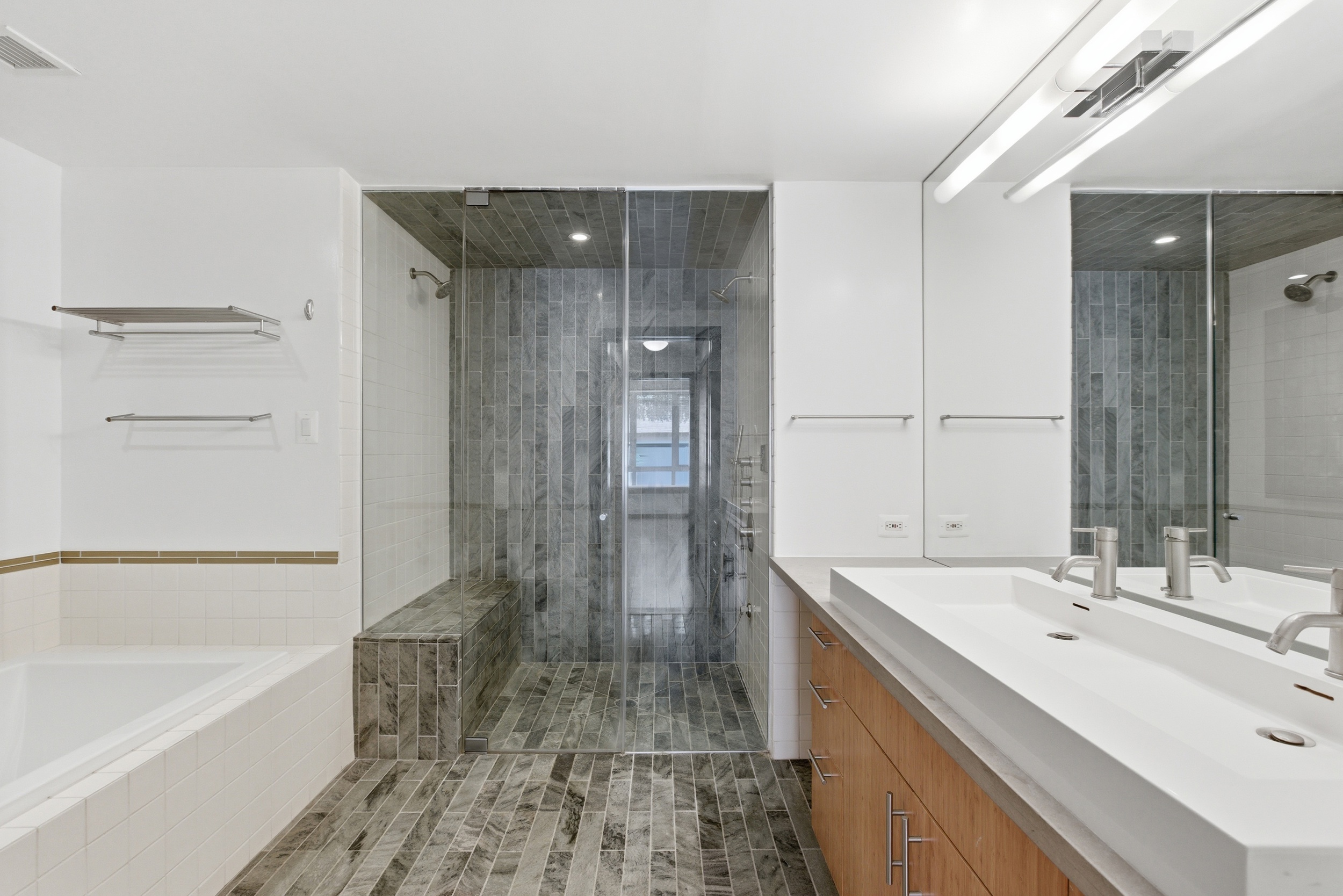 135 West 4th Street, Unit 3W Manhattan, NY 10012 - Photo 17 of 24 a bathroom with a double vanity sink mirror and shower