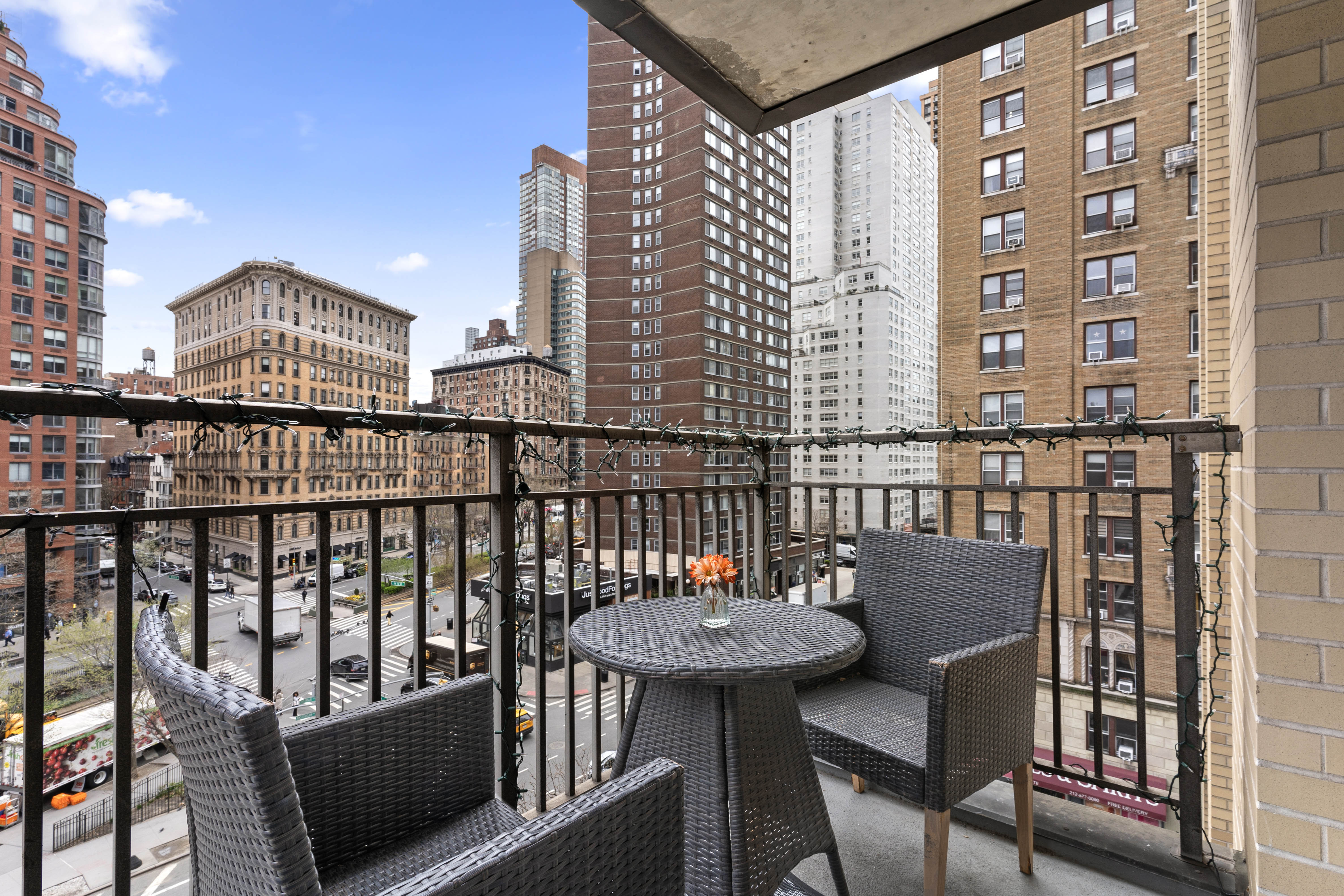 201 West 70th Street, Unit 7H Manhattan, NY 10023 - Photo 6 of 15 a view of a balcony with a table and chairs and wooden floor
