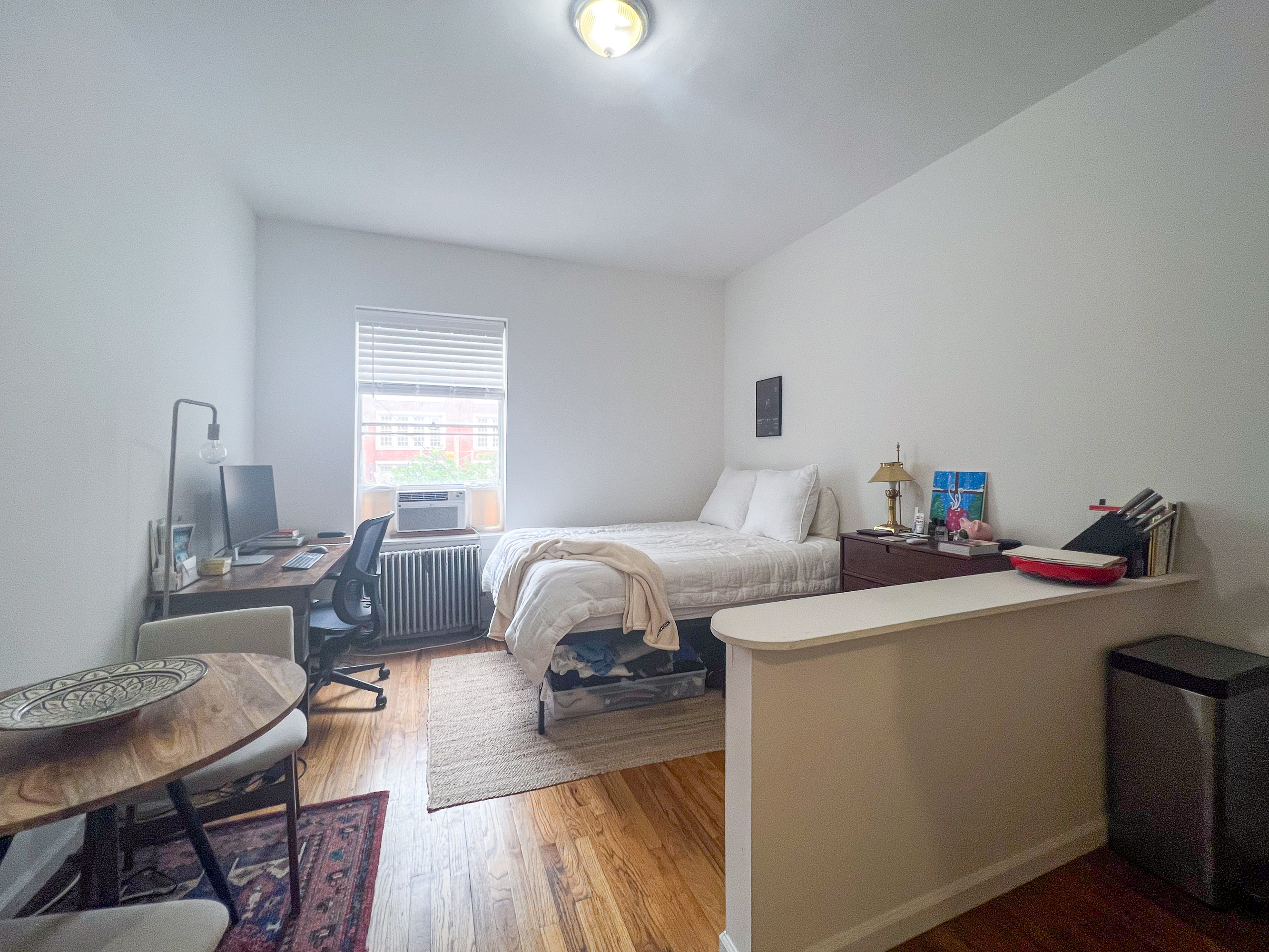 320 West 20th Street, Unit 14 Manhattan, NY 10011 - Photo 1 of 13 a bedroom with a bed and a wooden floor