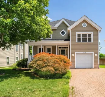 a front view of a house with a garden and yard