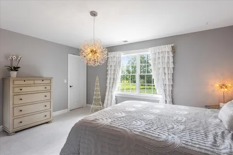 a spacious bedroom with a bed and a chandelier