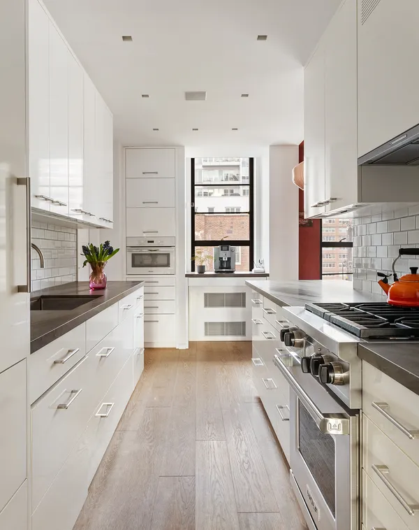 a large white kitchen with stainless steel appliances