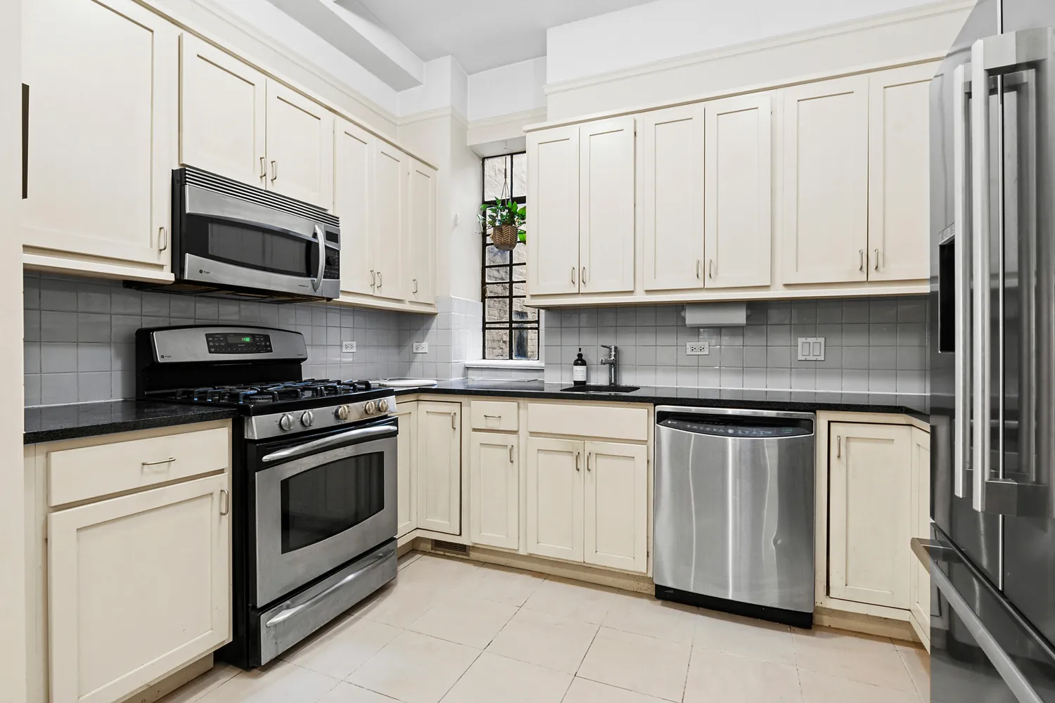 a kitchen with stainless steel appliances granite countertop a stove a sink and a microwave