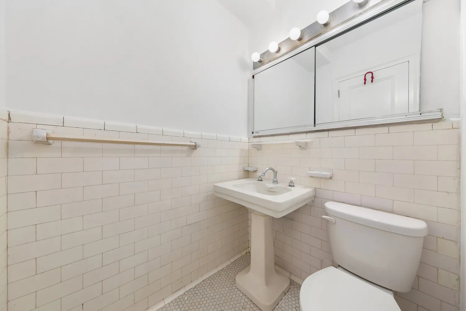 a bathroom with a sink a toilet and mirror