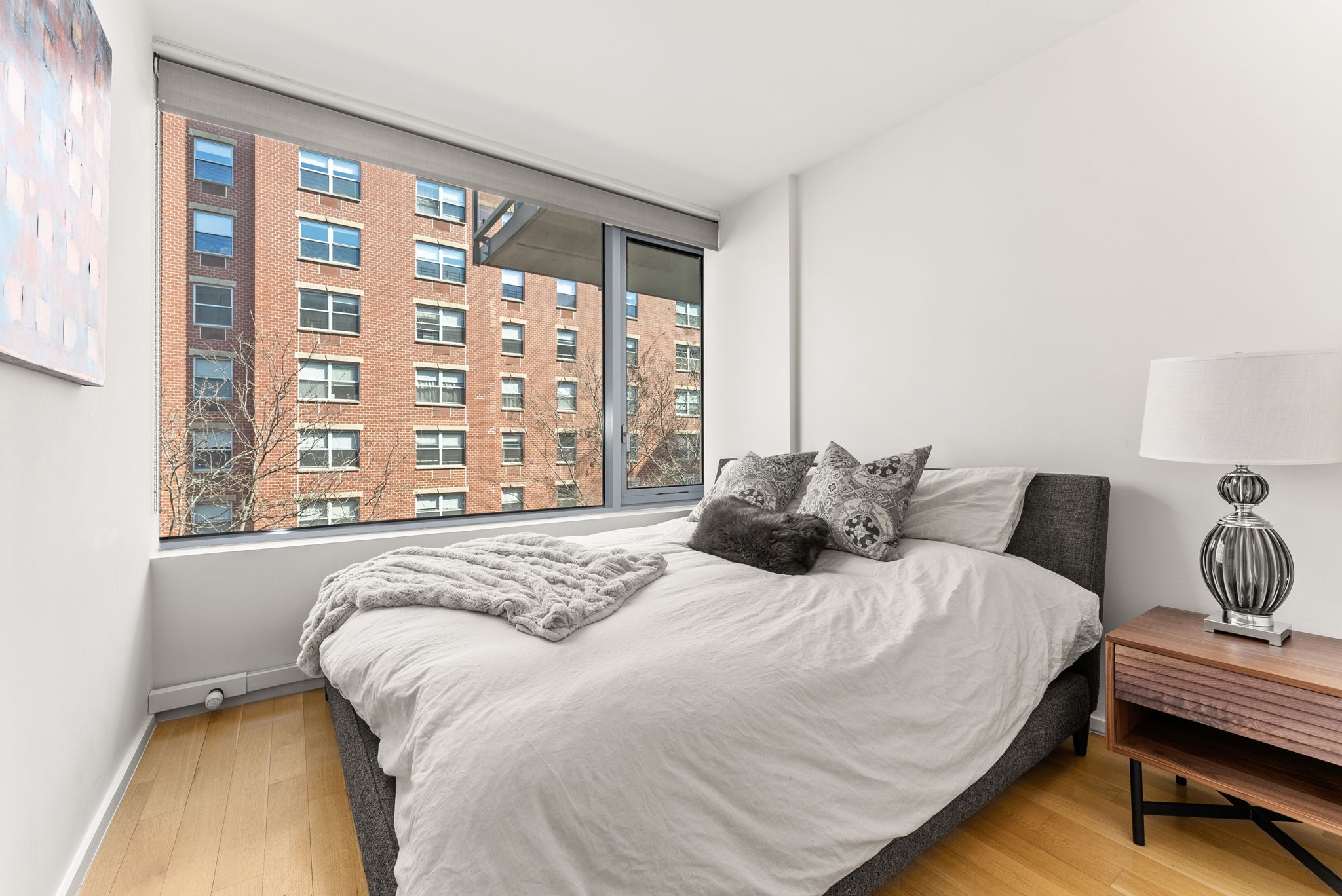 425 West 53rd Street, Unit 416 Manhattan, NY 10019 - Photo 12 of 19 a bed sitting in a bedroom next to a window