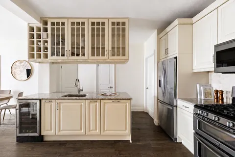 a kitchen with stainless steel appliances granite countertop a refrigerator a stove and a sink