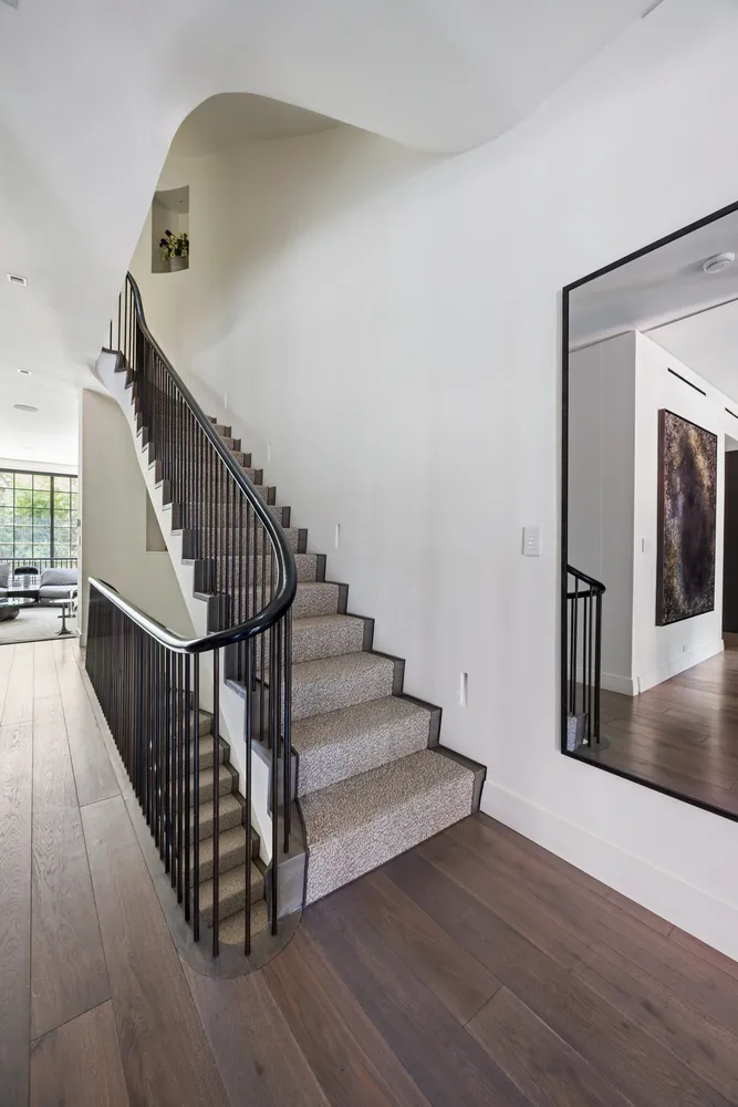 a view of a hallway with wooden floor and stairs