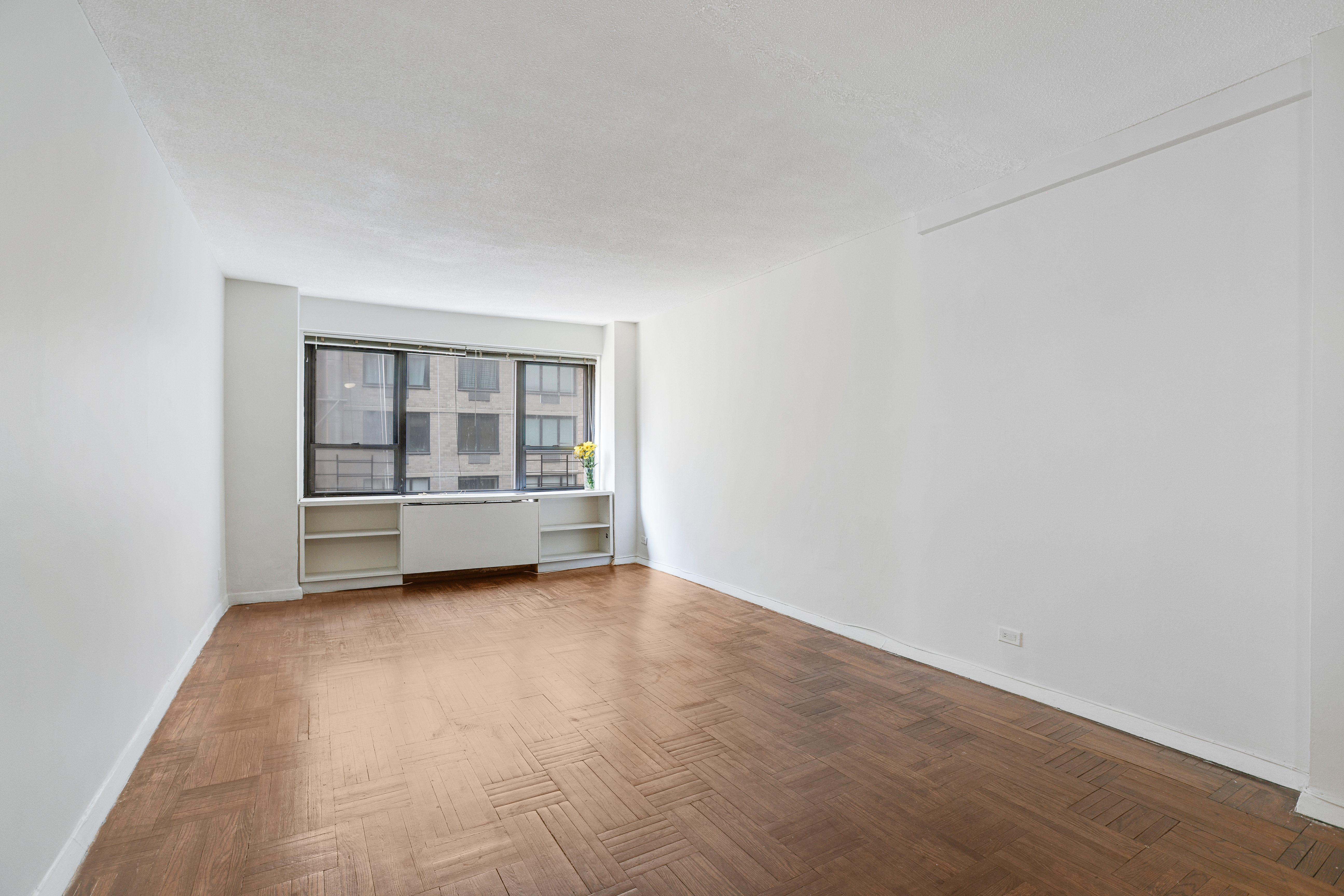 210 East 47th Street, Unit 7J Manhattan, NY 10017 - Photo 6 of 12 a view of an empty room with a window
