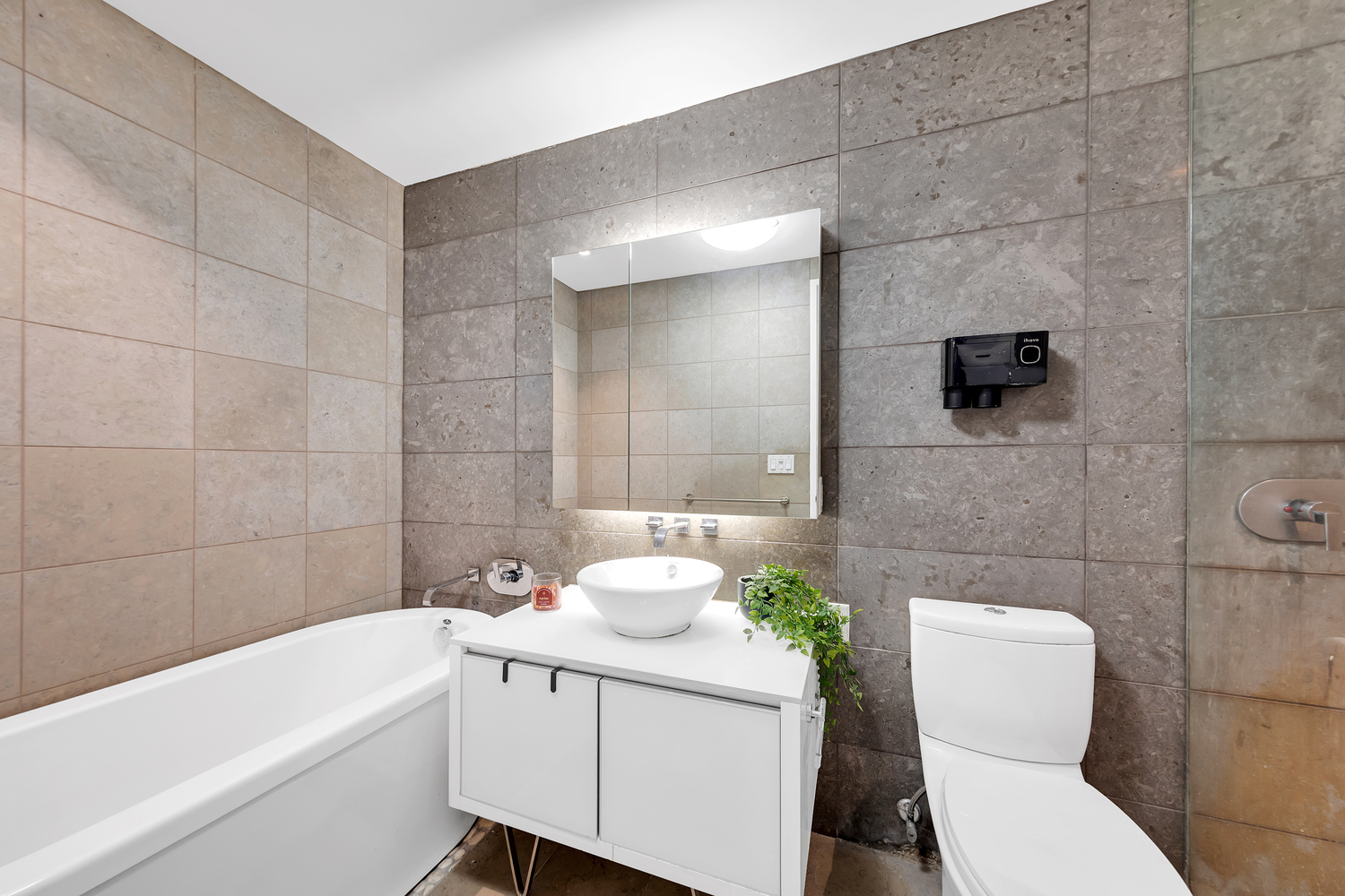 247 West 46th Street, Unit 2501 Manhattan, NY 10036 - Photo 4 of 6 a bathroom with a sink a toilet and shower