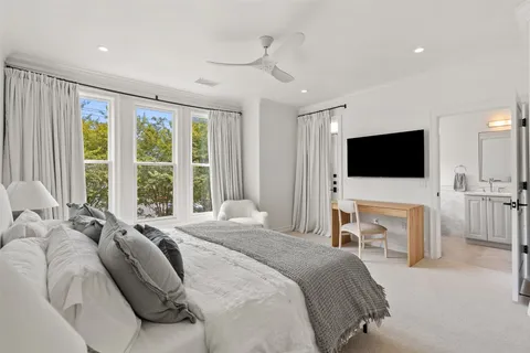 a spacious bedroom with a bed and a flat screen tv