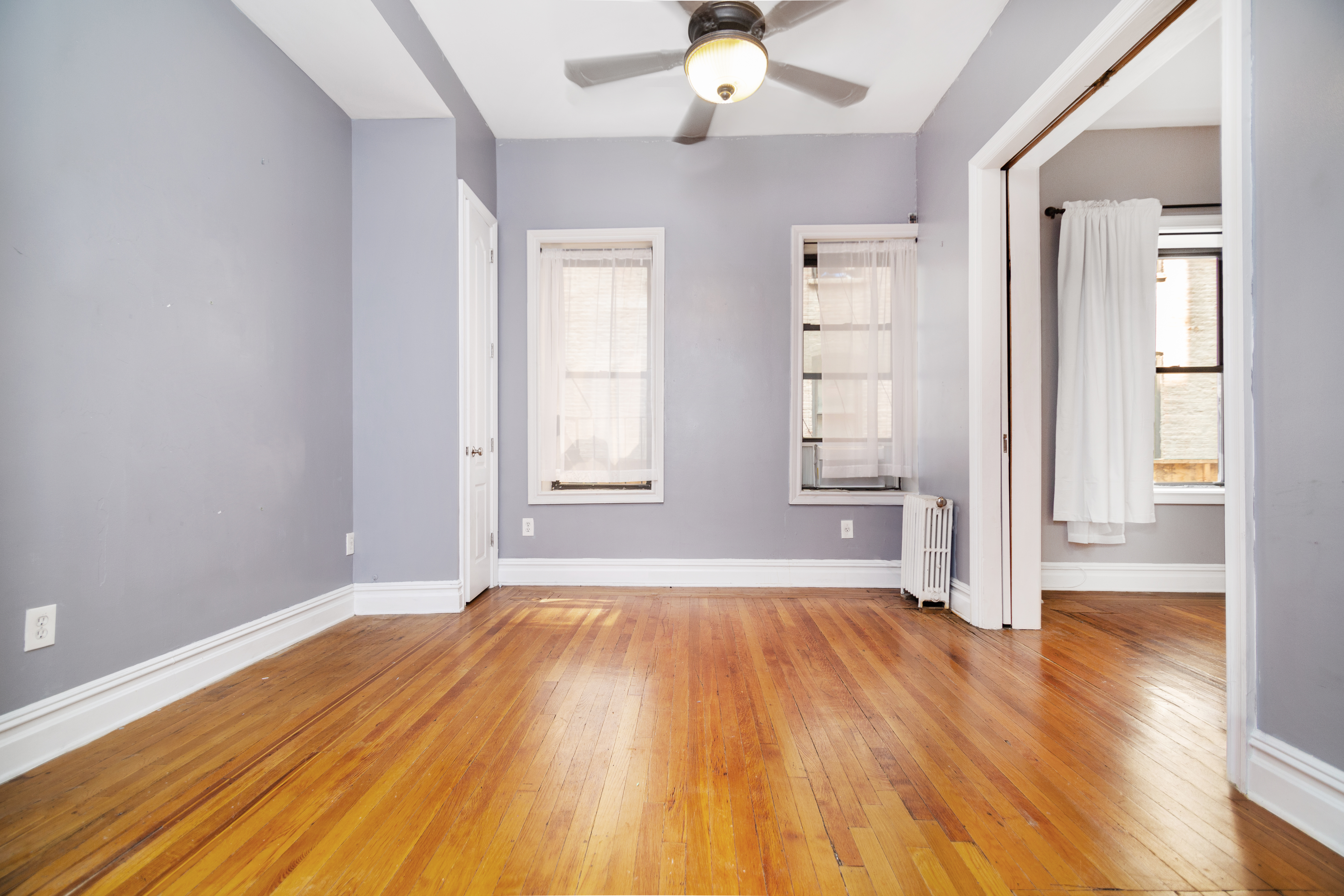 200 West 109th Street, Unit 2 Manhattan, NY 10025 - Photo 2 of 6 a view of an empty room with wooden floor and a window