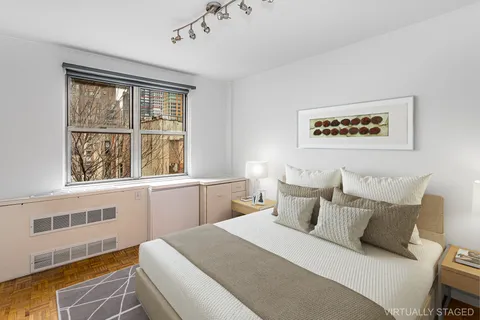 a bedroom with a bed and a large window