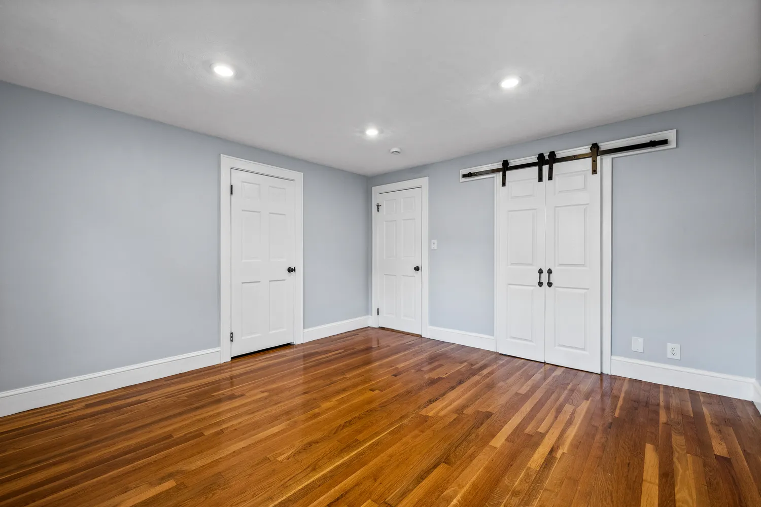 a view of empty room with wooden floor