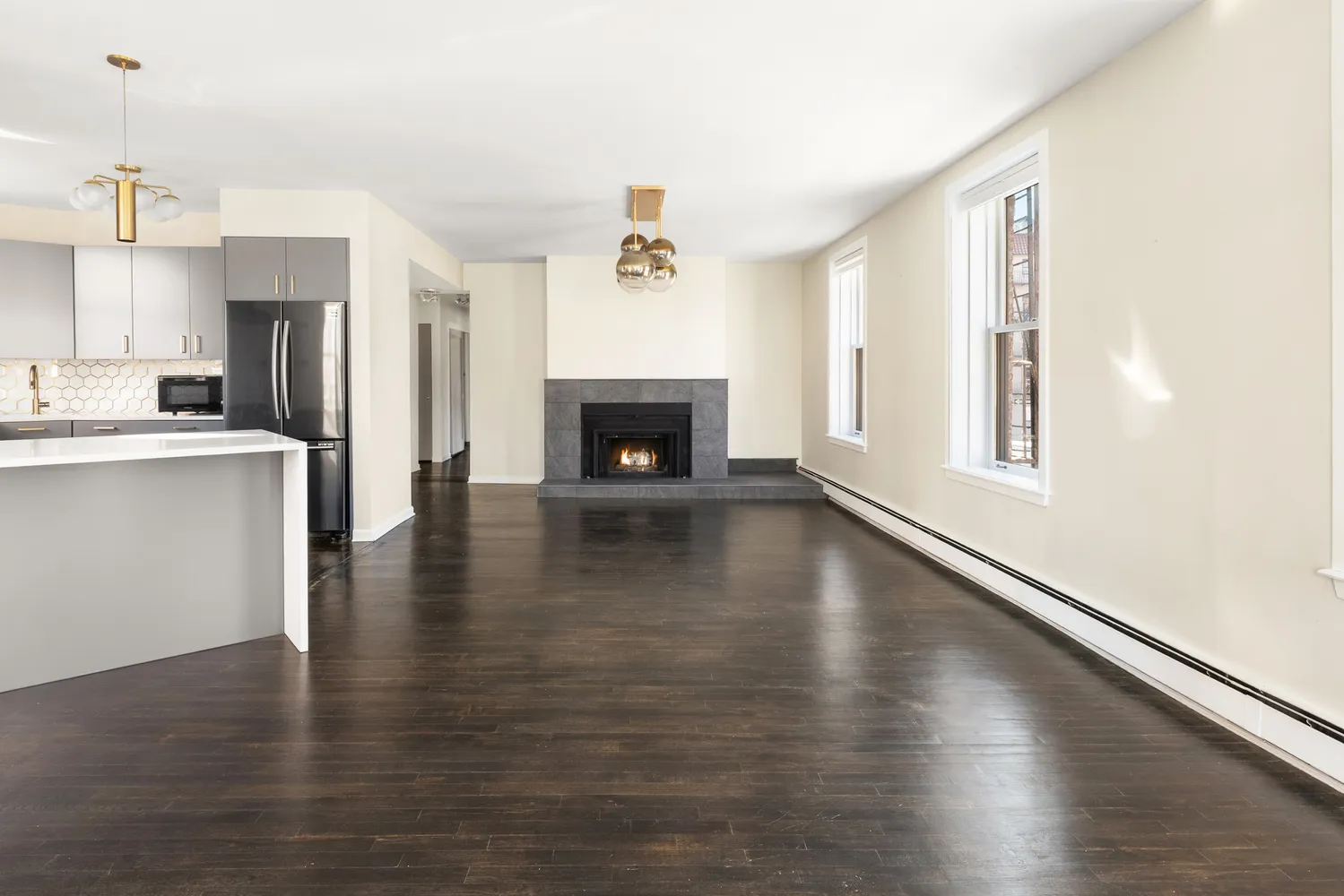 a view of a living room with wooden floor and a fireplace