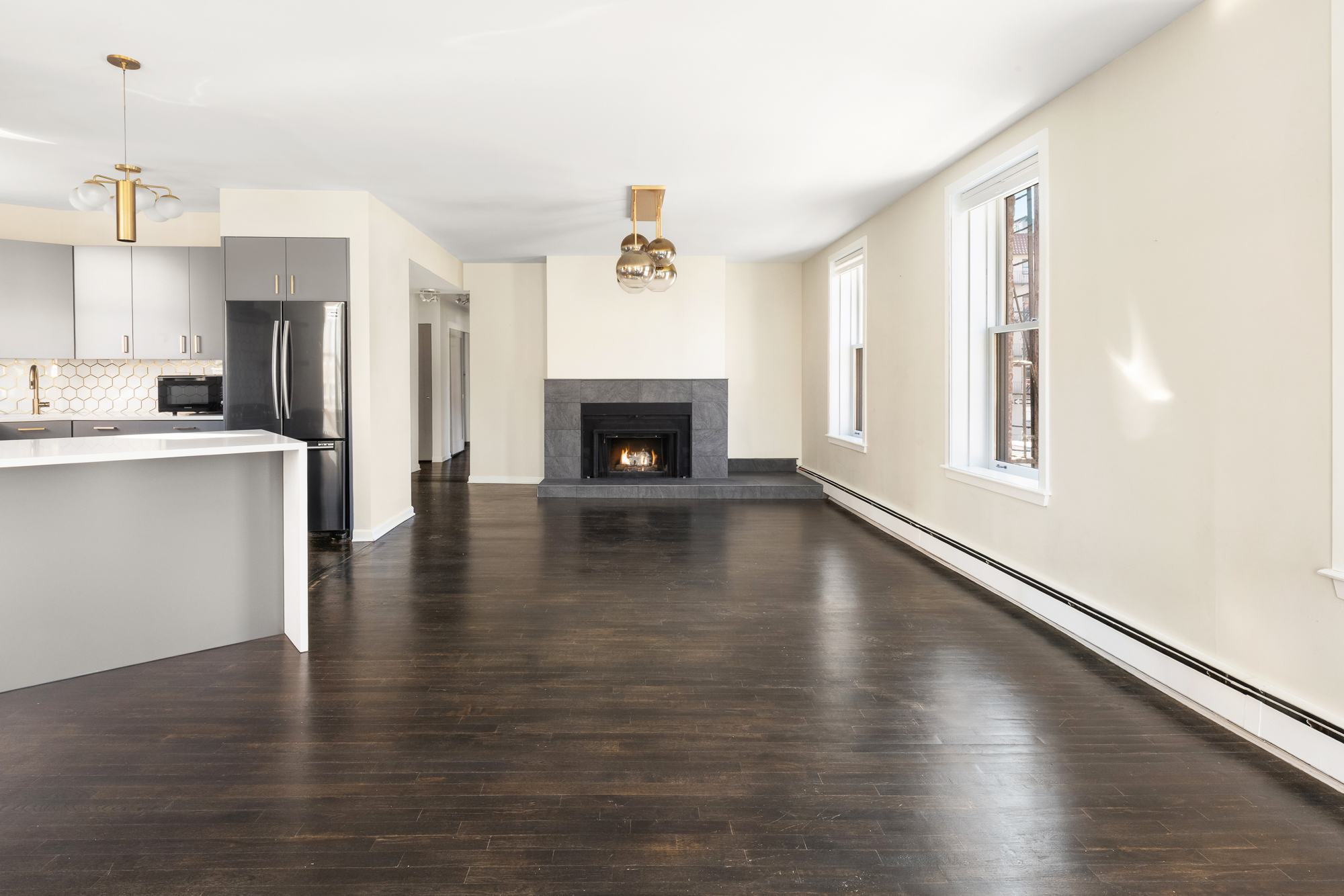 160 West 11th Street, Unit 1 Manhattan, NY 10011 - Photo 4 of 18 a view of a living room with wooden floor and a fireplace