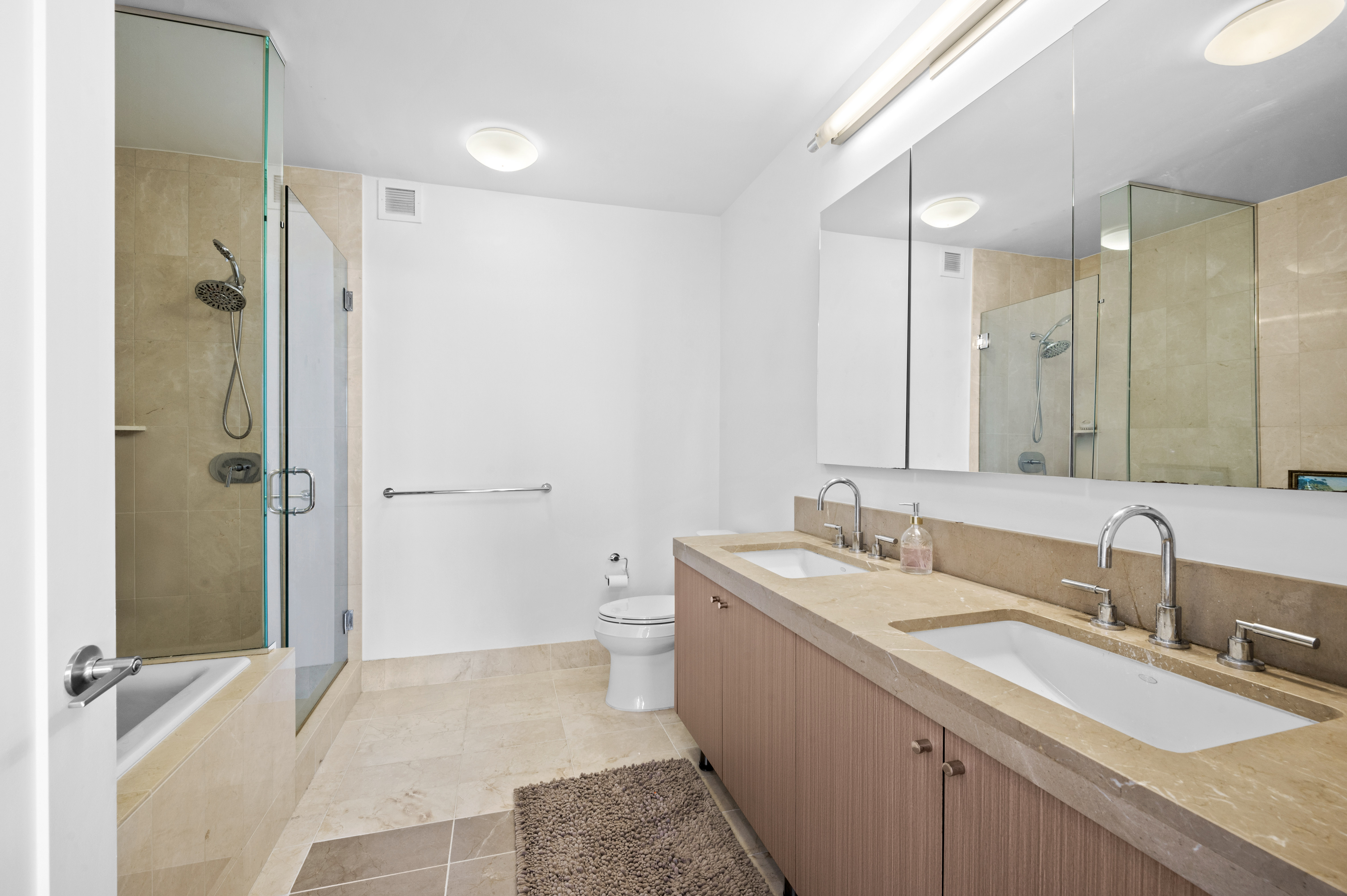 30 West Street, Unit 25G Manhattan, NY 10004 - Photo 9 of 17 a bathroom with a sink double vanity and a mirror