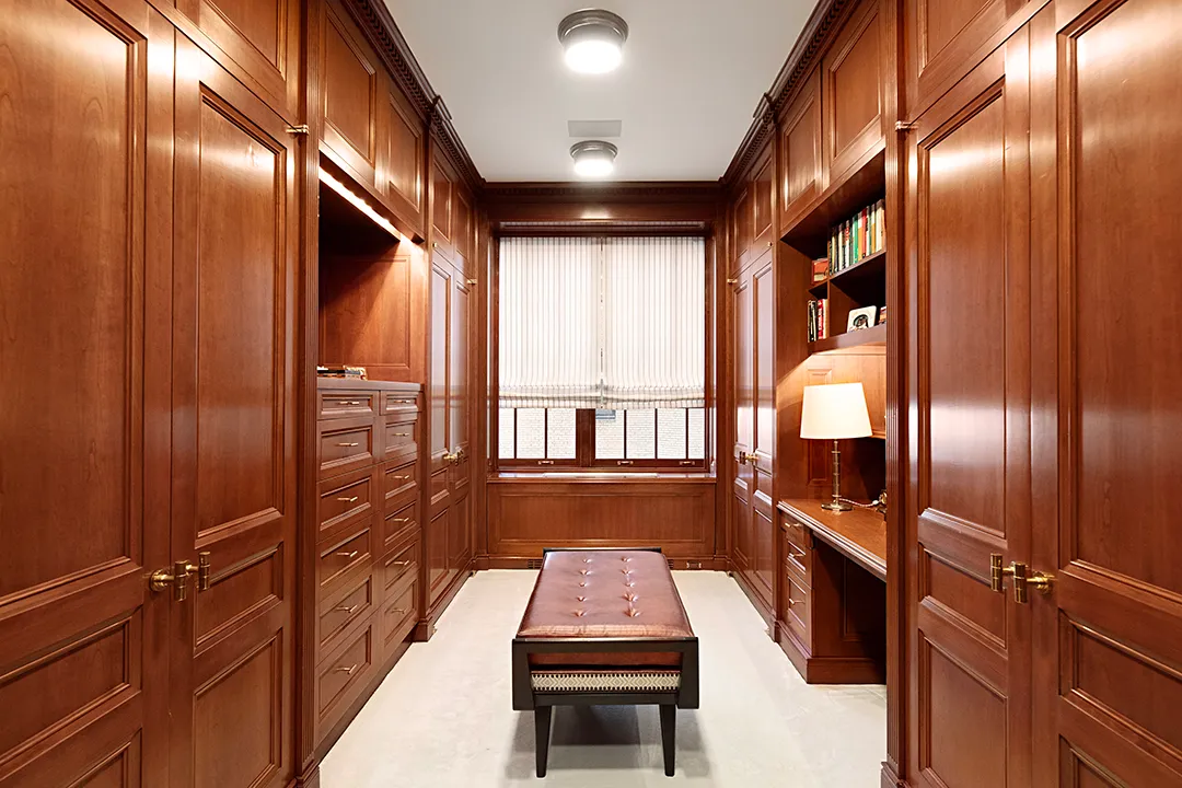 a bedroom with a bed couches and a flat tv screen