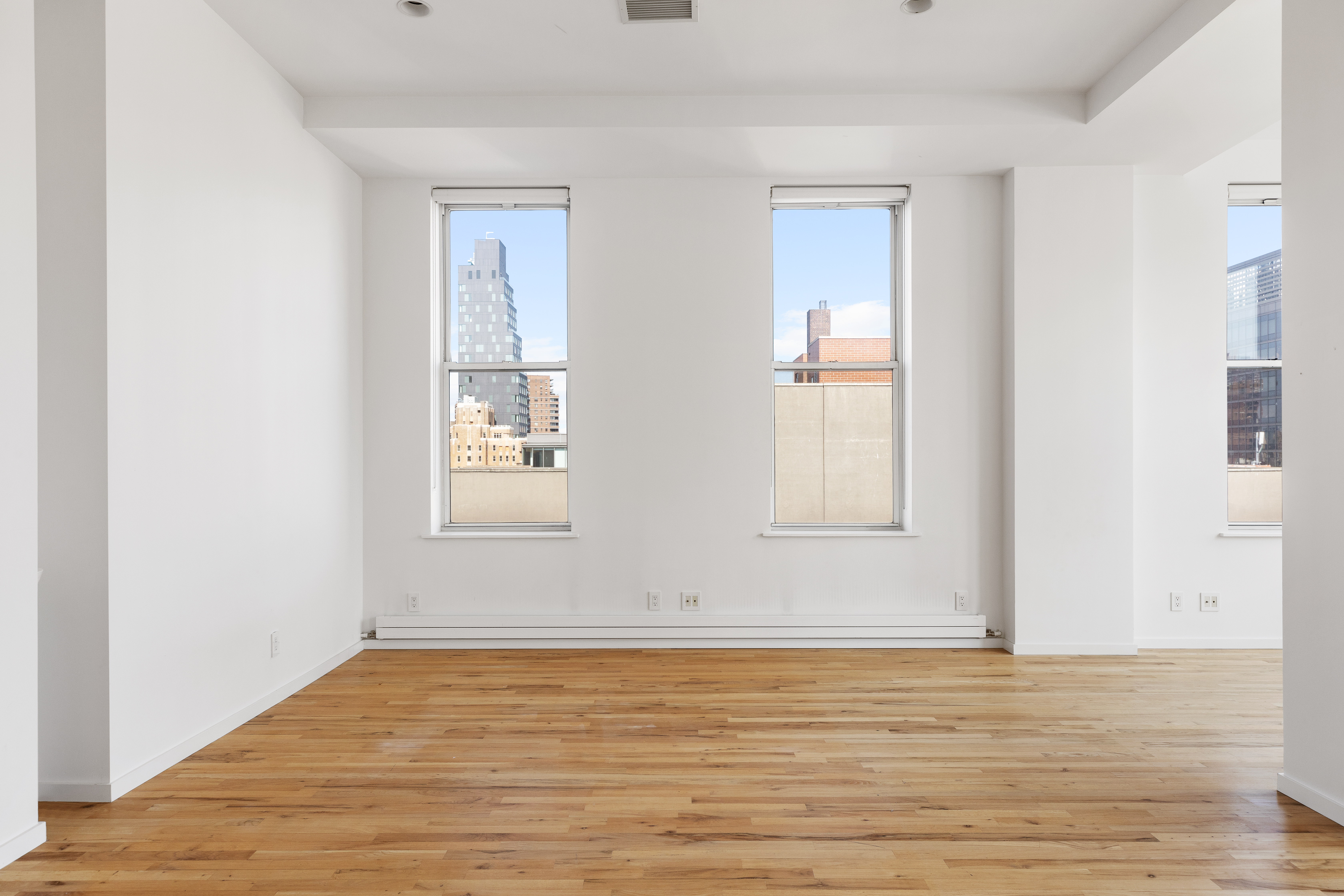 175 East Broadway, Unit 6D Manhattan, NY 10002 - Photo 6 of 18 a view of wooden floor and windows in a room