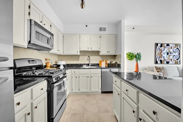 a kitchen with cabinets stainless steel appliances and a sink