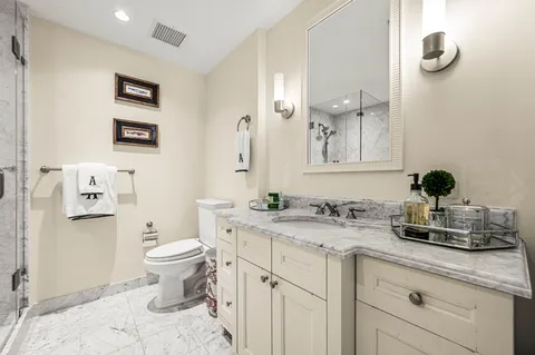 a bathroom with a toilet sink and mirror