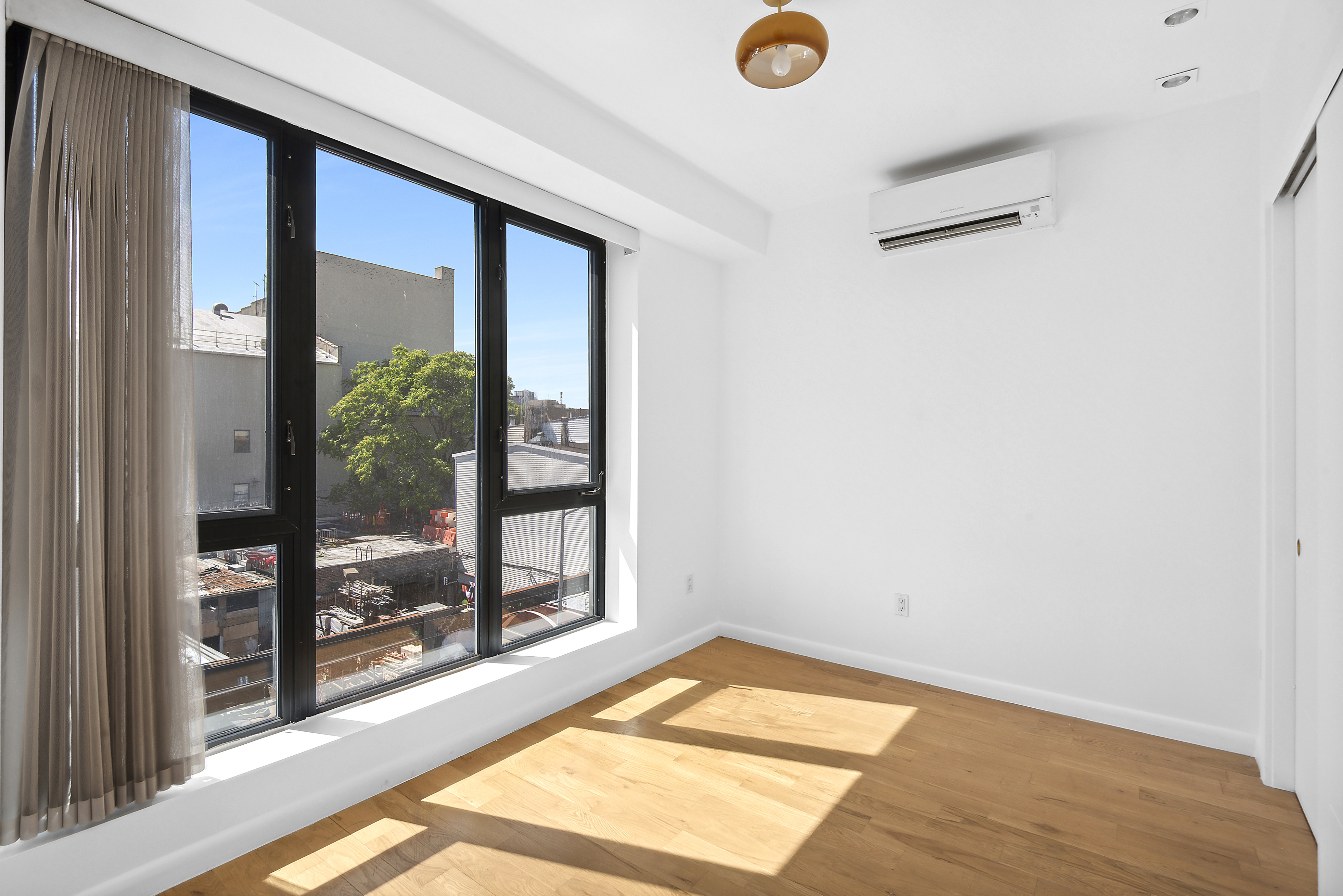 27 Dodworth Street, Unit PHF Brooklyn, NY 11221 - Photo 4 of 18 a view of a room with gym equipment and a large window