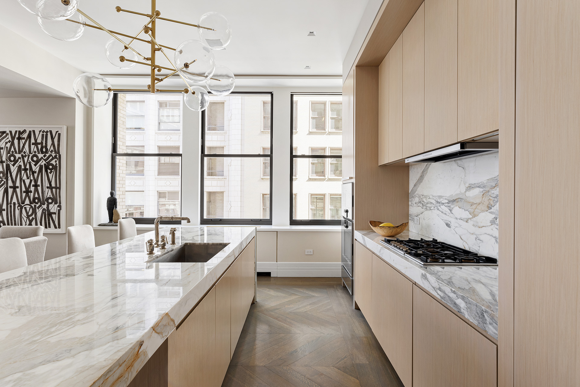 212 5th Avenue, Unit 9B Manhattan, NY 10010 - Photo 7 of 16 a kitchen with stainless steel appliances kitchen island granite countertop a sink and white cabinets