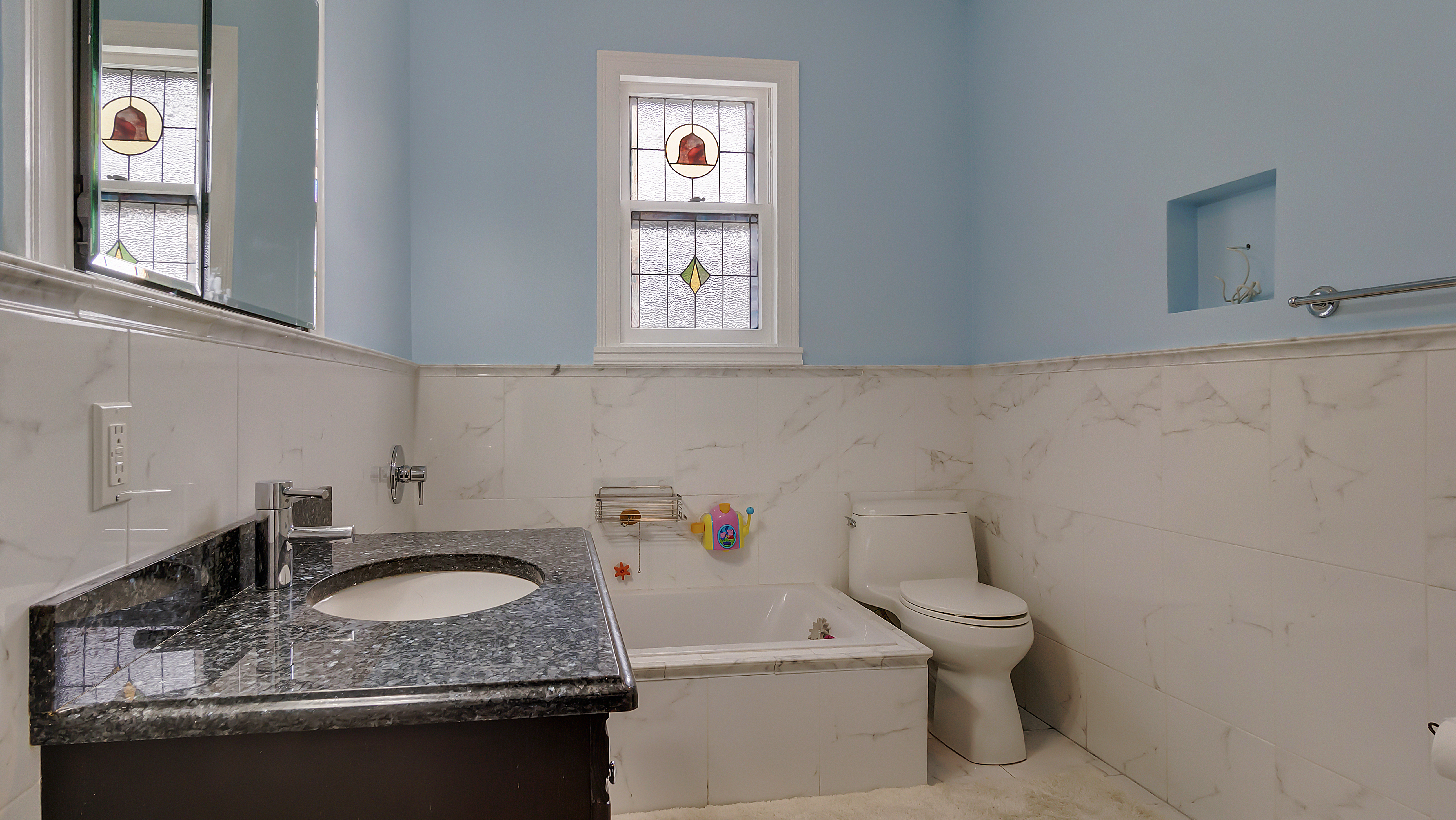 278 Amherst Street Brooklyn, NY 11235 - Photo 17 of 24 a bathroom with a granite countertop sink a toilet and a window