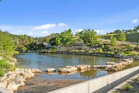 an aerial view of residential house with outdoor space and trees all around