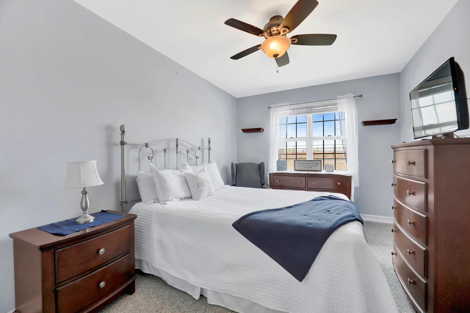 a bedroom with a bed and a tv on the dresser