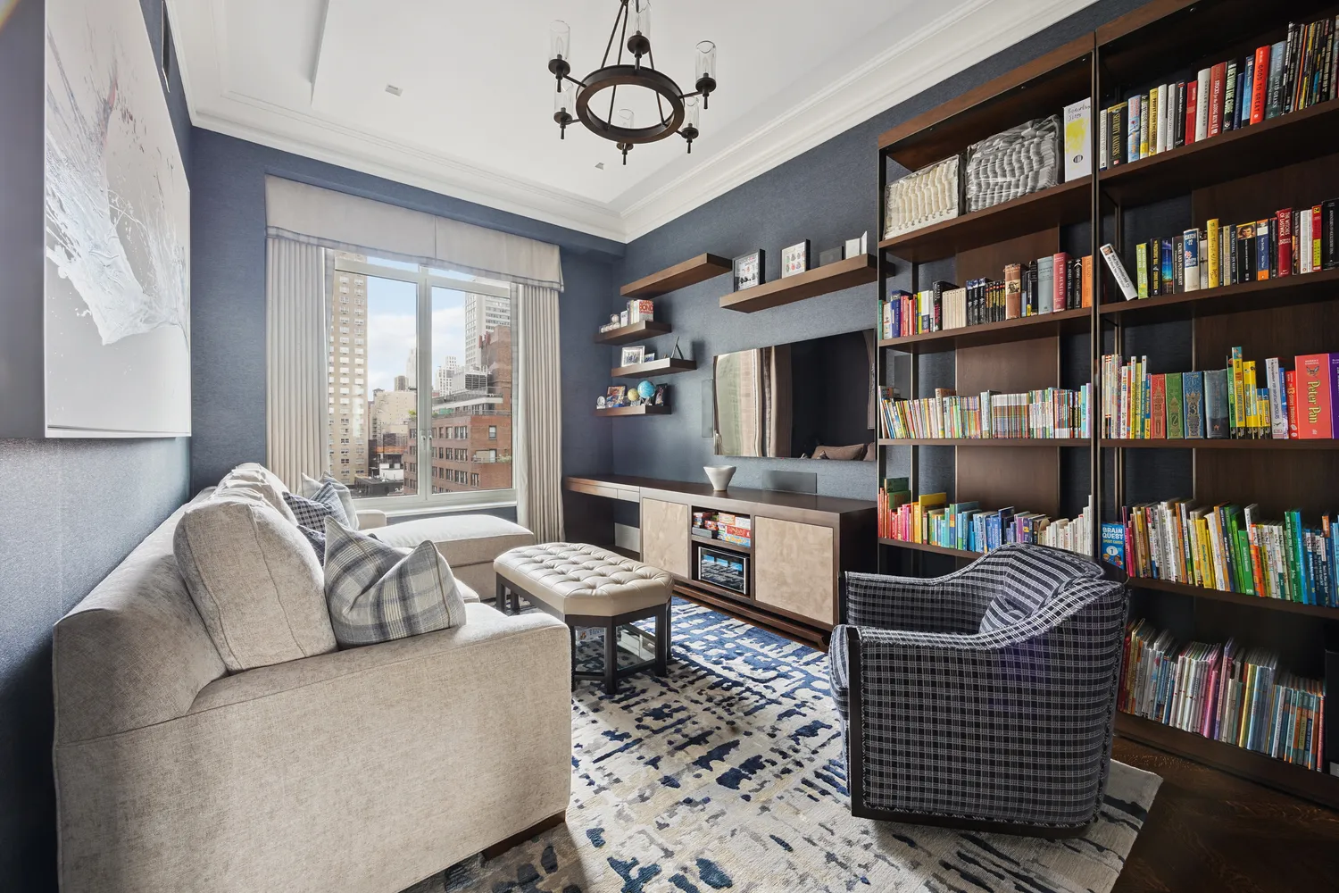 a living room with furniture a bookshelf and a window