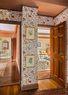 a view of a hallway with wooden floor and a living room