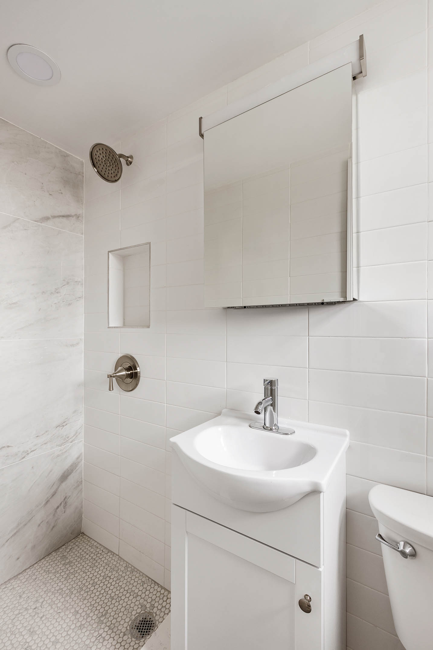 122 Ashland Place, Unit 15B Brooklyn, NY 11201 - Photo 7 of 15 a bathroom with a sink a toilet and mirror