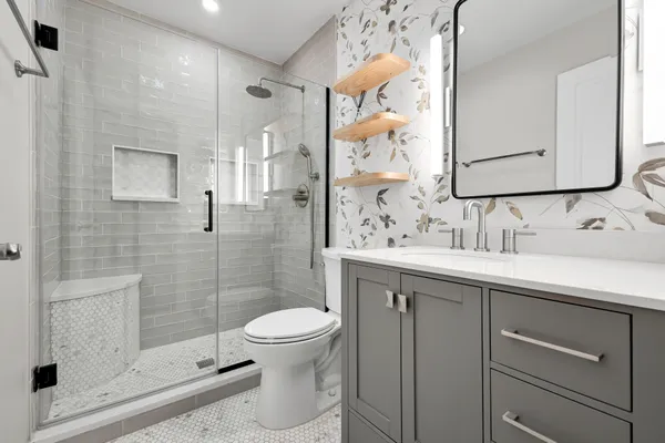 a bathroom with a sink a toilet and shower