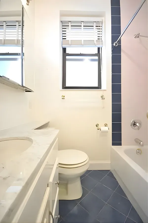 a bathroom with a granite countertop toilet a sink and a bathtub