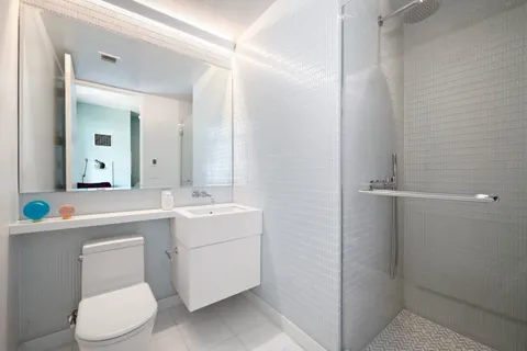 a bathroom with a sink a toilet and a mirror