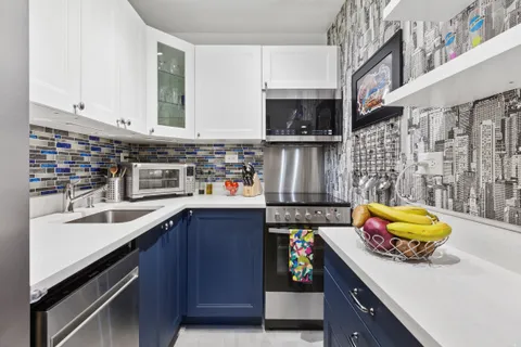 a kitchen with stainless steel appliances kitchen island granite countertop a sink a stove and a microwave
