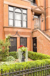 front view of a brick house with a small yard