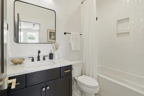 a bathroom with a granite countertop sink a toilet and a mirror