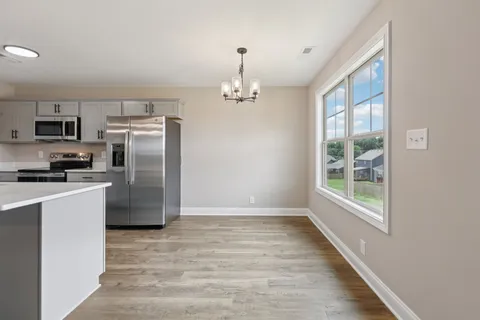 a kitchen with stainless steel appliances granite countertop a refrigerator a stove top oven a sink and dishwasher