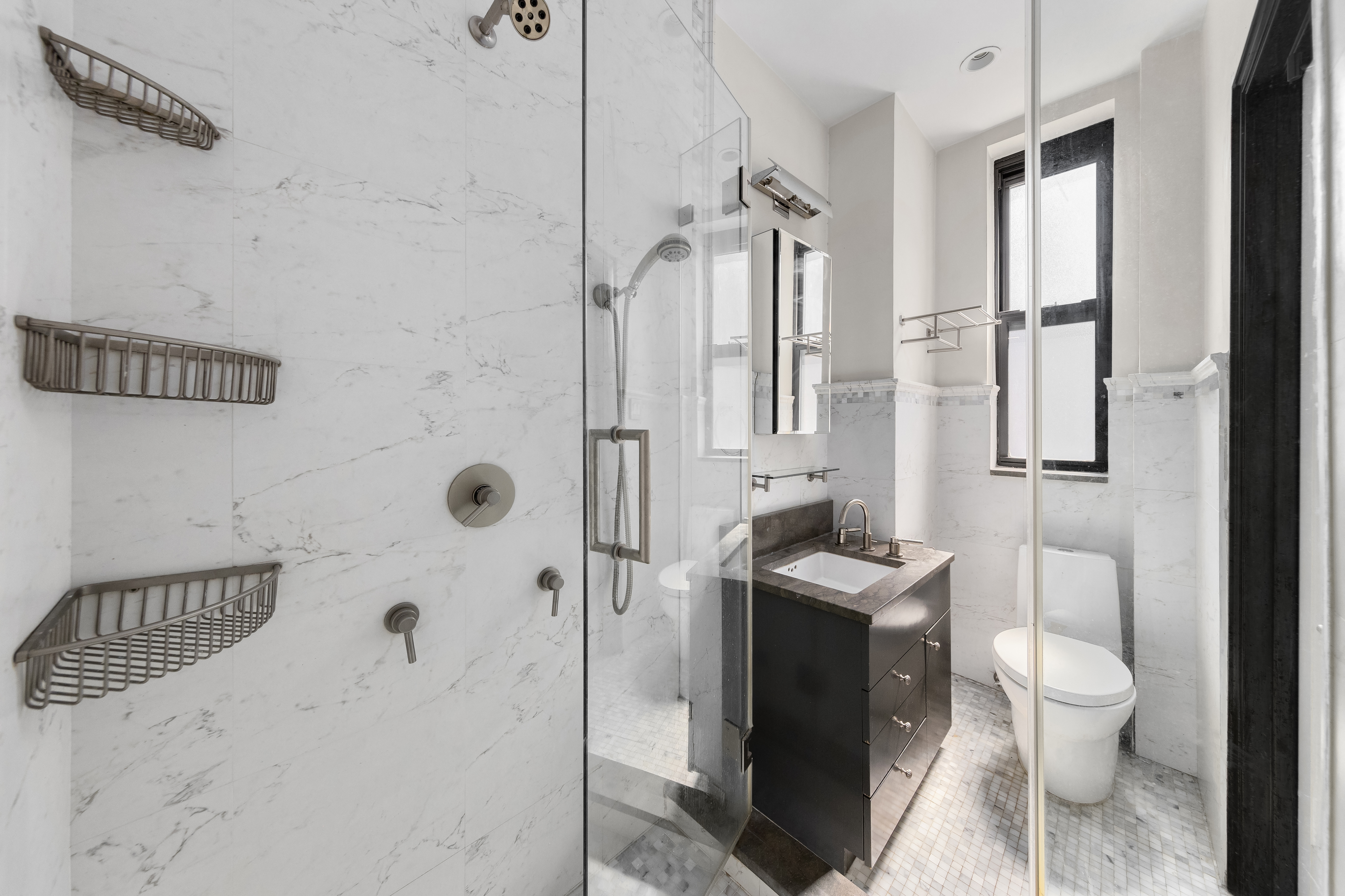 205 West 54th Street, Unit 10E Manhattan, NY 10019 - Photo 7 of 8 a bathroom with a granite countertop sink a toilet and shower