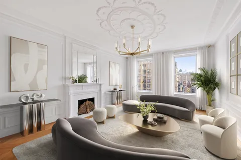 a living room with furniture a fireplace and a chandelier